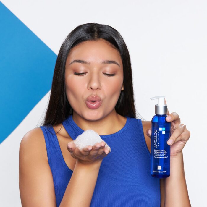 Skincare product photo with a model blowing out foam of her hand and holding a cleansing bottle