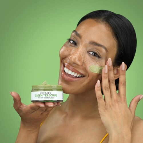 Model is showing a smear on her face against a green background