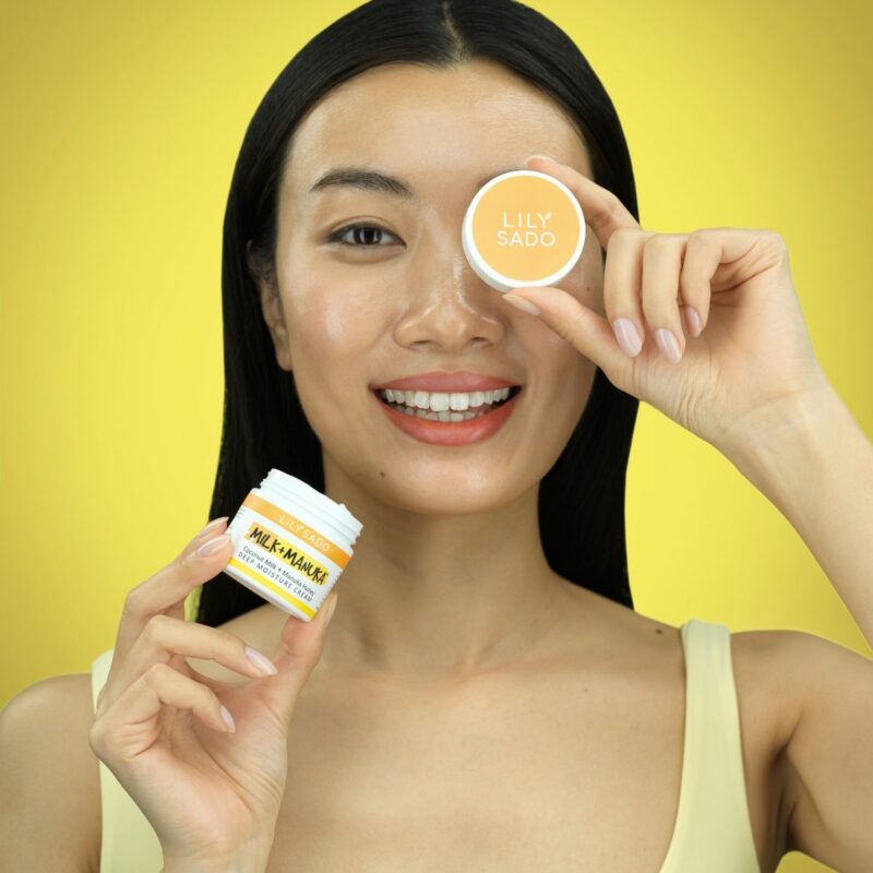 Model holds the cap in front the eye against the yellow background