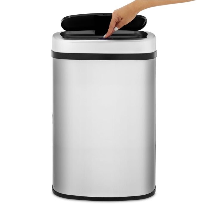 Female hand model pressing button of an electric bin to open the lid.