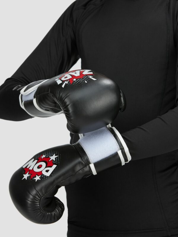 Action photography of a model wearing black boxing gloves and black t-shit.