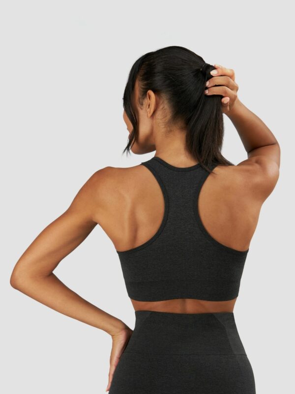 Clothing photography of a female model from the back wearing sports suit in black