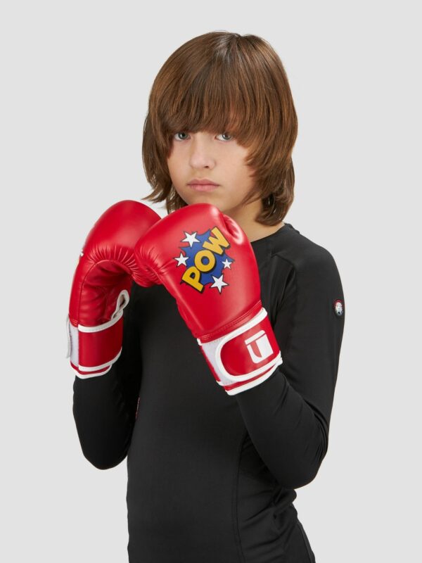 Action photography of male child model wearing red pow zap boxing gloves.