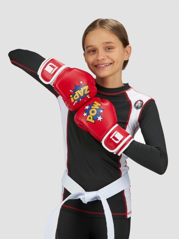 Action photography of female child model wearing red pow zap boxing gloves.