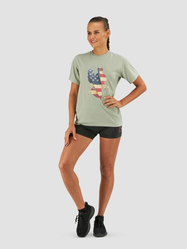 Clothing photography of model wearing tigear sport suit, black shorts with green shirt and black trainers on a plain background.