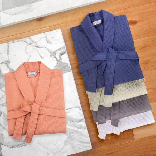 Creative lifestyle clothing photography of multi colored bath robes placed on a wooden and marble background
