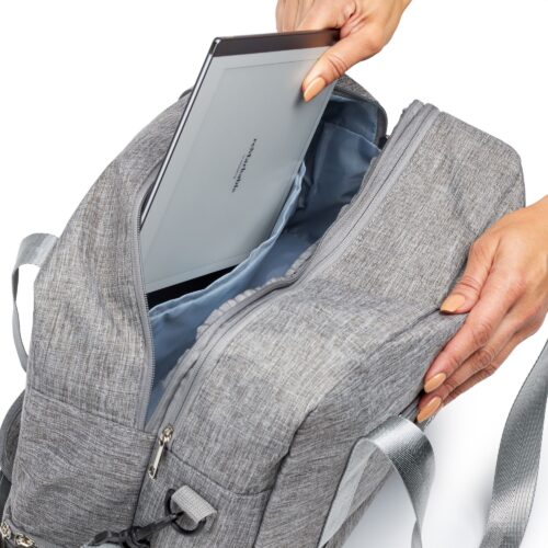 Action shot of female hands placing remarkable tablet inside a travel bag by Isa Aydin NJ NY LA