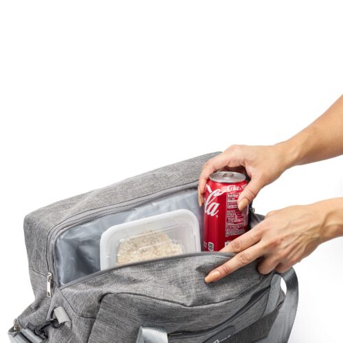 Action shot of a female hand model placing Coca Cola and other food items in a travel bag.