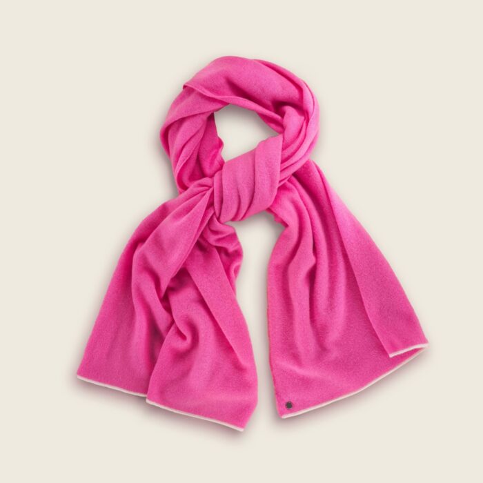 Lay flat photography of a pink colored scarf folded in a creative way.