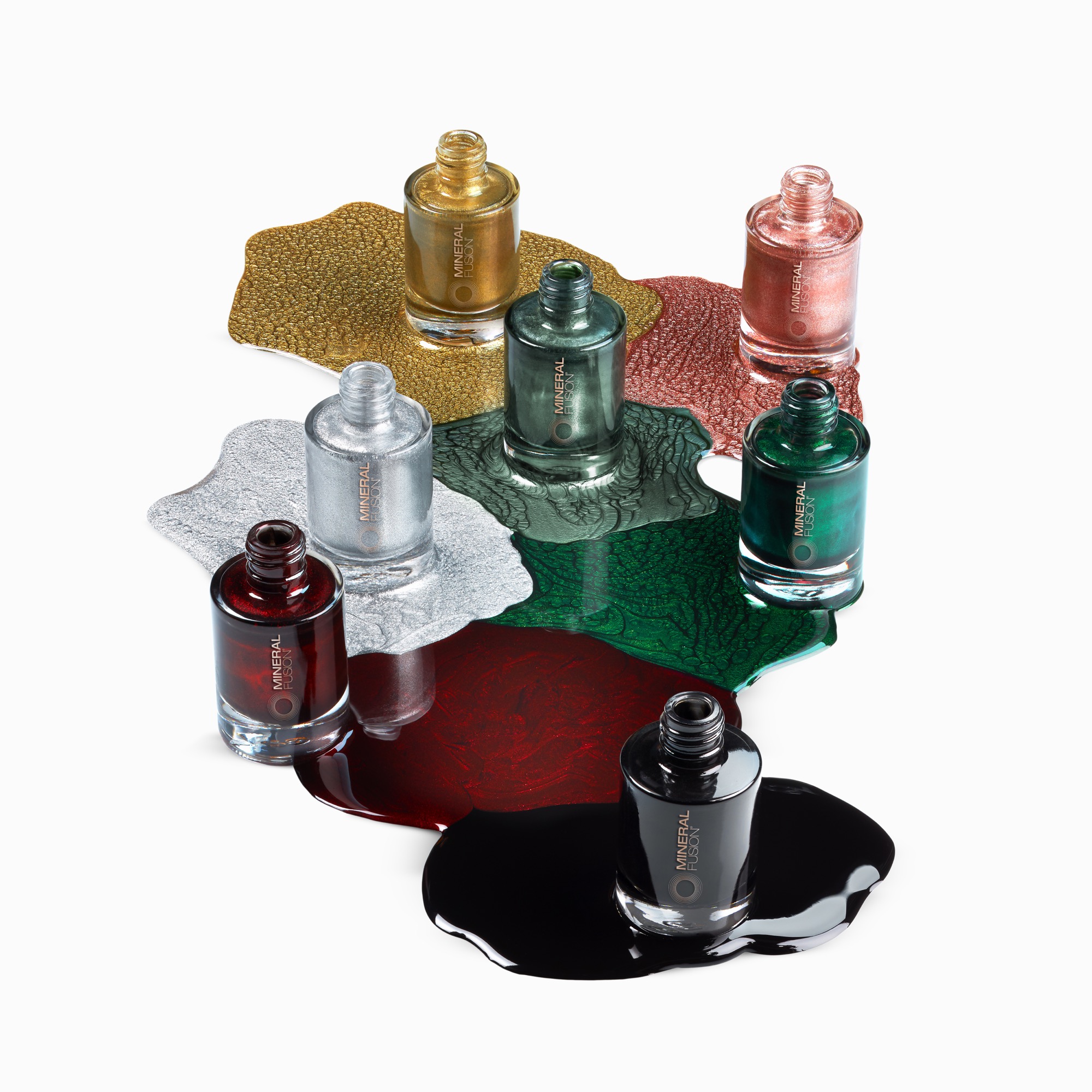 Creative cosmetics photography of seven nail polish bottles with artsy pours of each color setup using glitters shot by Isa Aydin nj ny la