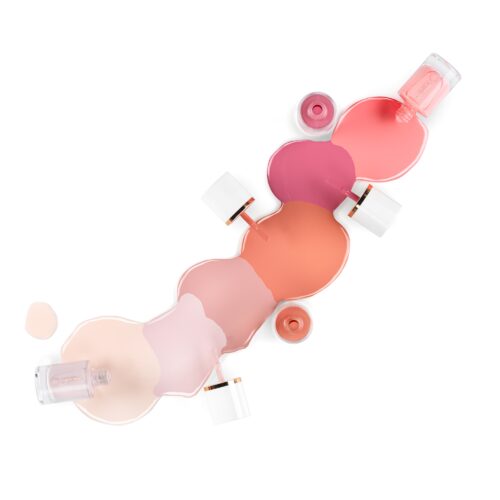Creative cosmetics photography of different shades of nail polish bottles in artsy pours setting by Isa Aydin nj ny la